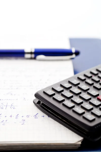 Scientific calculator on the maths workbook with blue pen — Stock Photo, Image