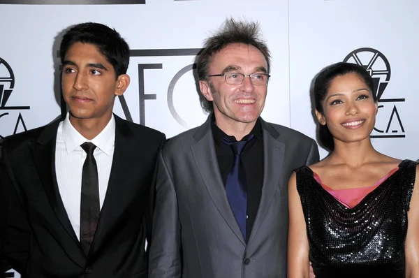 Dev patel mit danny boyle und freida pinto — Stockfoto