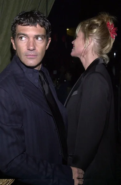 Antonio Banderas looks to see if anyone saw him sneak a puff off Melanie Griffith's cigarette — Stock Photo, Image