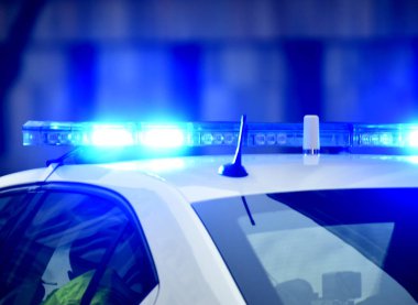 Gece polis arabasında mavi teşhirci. Polis arabası iş başında. Geceleri mavi ışıkları olan polis arabası. Seçici odak