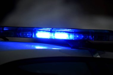 Gece polis arabasında mavi teşhirci. Polis arabası iş başında. Geceleri mavi ışıkları olan polis arabası. Seçici odak