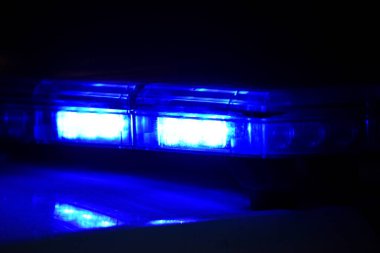 Gece polis arabasında mavi teşhirci. Polis arabası iş başında. Geceleri mavi ışıkları olan polis arabası. Seçici odak