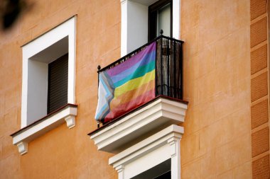 Madrid 'in Chueca semtinde homoseksüel LGTBI haklarını temsil eden bir gökkuşağı bayrağı bulunan evin ön cephesi. Madrid, İspanya 'da Chueca bölgesinde bir evin balkonlarında gökkuşağı bayrakları.            