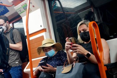                    Madrid, Spain June 13, 2022: People in face masks ride the Madrid metro. People wearing mask checking his smartphone in the Madrid underground. Social distance and covid concept in Spain            