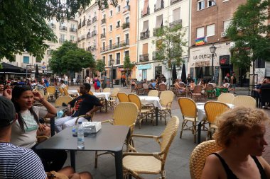          Madrid, İspanya - 14 Haziran 2022: Castiza Chueca Meydanı, barlar ve mağazalar dolusu eşcinsel gururuyla Madrid 'de. İnsanlar Chueca 'da akşam içkisinin tadını çıkarıyor.                      