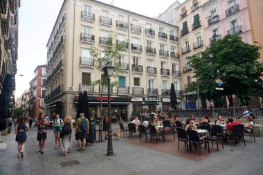          Madrid, İspanya - 14 Haziran 2022: Castiza Chueca Meydanı, barlar ve mağazalar dolusu eşcinsel gururuyla Madrid 'de. İnsanlar Chueca 'da akşam içkisinin tadını çıkarıyor.                      