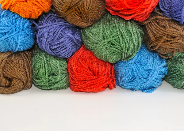 Espinhos multicoloridos de fios para tricotar, empilhados um sobre o outro . — Fotografia de Stock