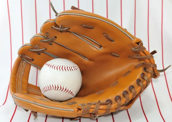 Bola de béisbol en guante sobre fondo rayado claro . — Foto de Stock