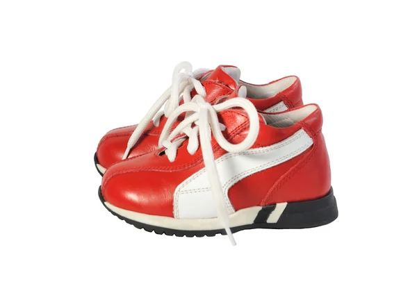 Paire de chaussures pour enfants sur le cordon rouge sur fond blanc. Vue latérale . — Photo