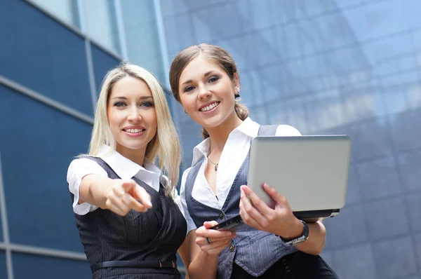 Deux jeunes femmes d'affaires attrayantes regardant vers l'ordinateur portable — Photo