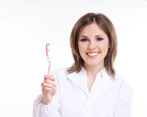 Junge attraktive Zahnärztin mit rosa Zahnbürste isoliert auf weiß — Stockfoto