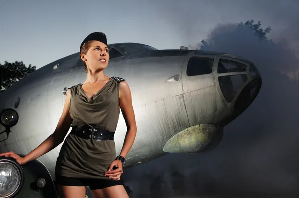 Jovem soldado feminino atraente com o avião e carro — Fotografia de Stock