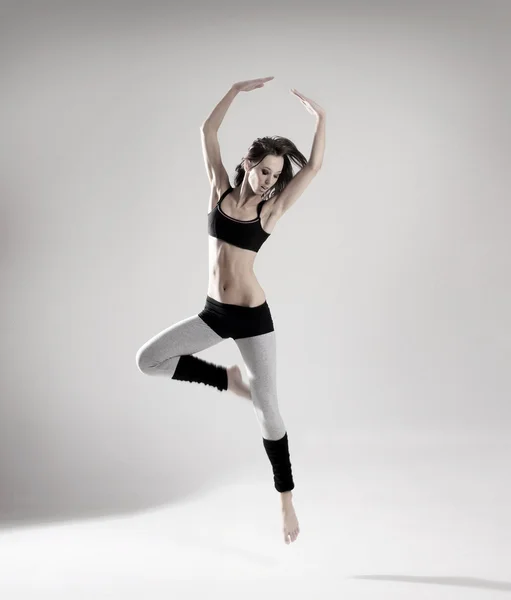 Young and sexy modern dancer over grey background — Stock Photo, Image