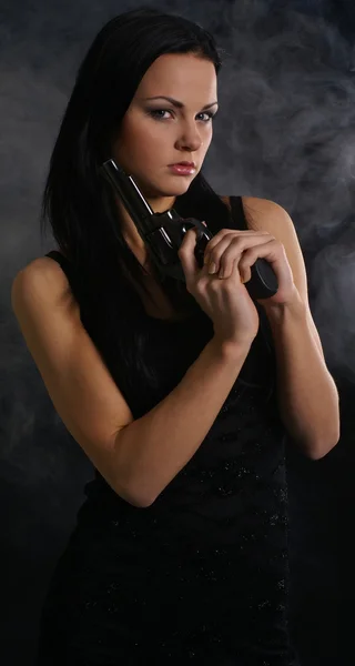 Sexig kvinna med vapen på rökiga bakgrund Stockbild