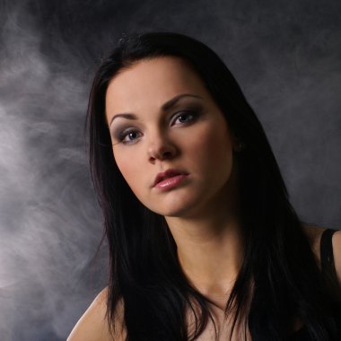 mujer sexy con arma sobre fondo ahumado