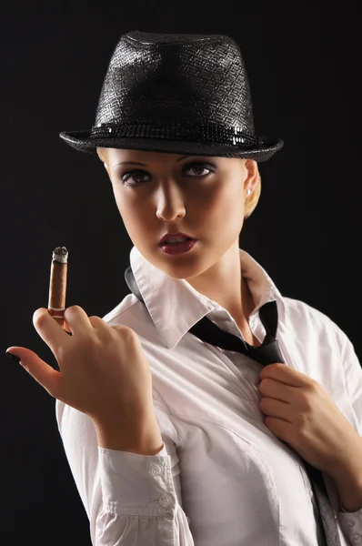 Jeune gangster féminin attrayant fumant cigare sur fond sombre — Photo