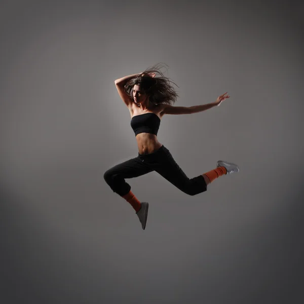 Young and sexy modern dancer over grey background — Stock Photo, Image