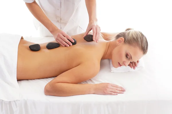 Young attractive woman getting hot stone treatment — Stock Photo, Image