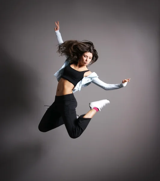 Jeune et sexy danseuse moderne sur fond gris — Photo