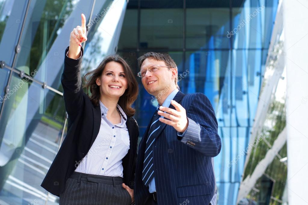 Conceptual photo of businesswoman showing something to her assistant