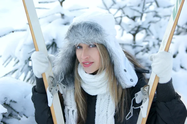 Женщина с лыжами на зимнем фоне — стоковое фото