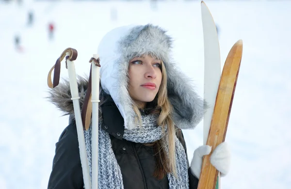 冬の背景の上のスキーを持つ女性 — ストック写真