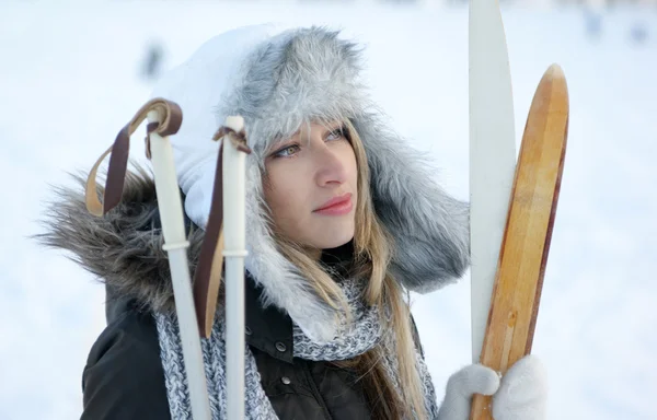 Mujer con esquí sobre fondo de invierno — Foto de Stock