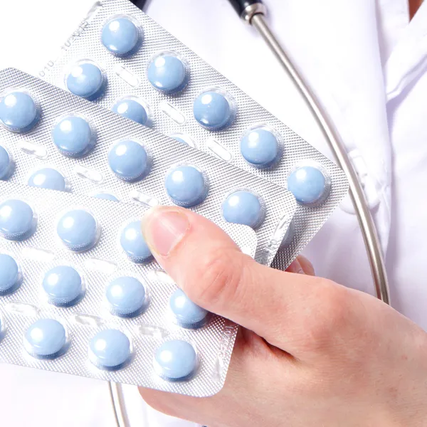 Doctor giving blue medicine pills — Stock Photo, Image