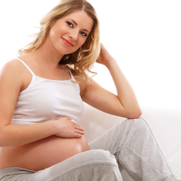 Joven mujer embarazada atractiva en el sofá —  Fotos de Stock
