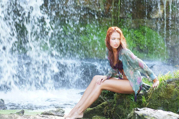 Young and beautiful girl in bikini taking bath in a waterfall — Stock Photo, Image