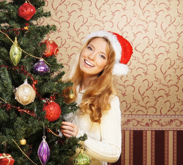 Krásná dospívající dívka zdobí vánoční stromek — Stock fotografie