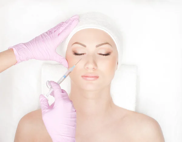 Beautiful woman gets an injection in her face Stock Photo