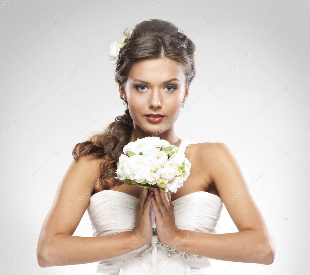 Young attractive bride with the bouquet of white roses