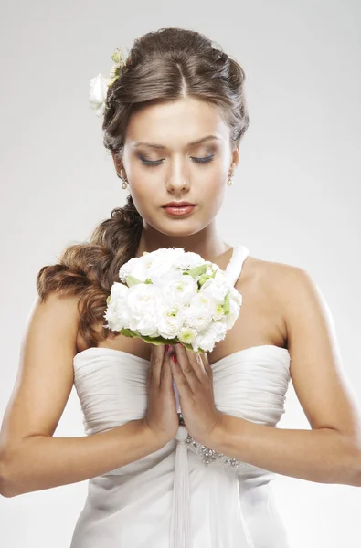 Giovane sposa attraente con il bouquet di rose bianche Immagine Stock