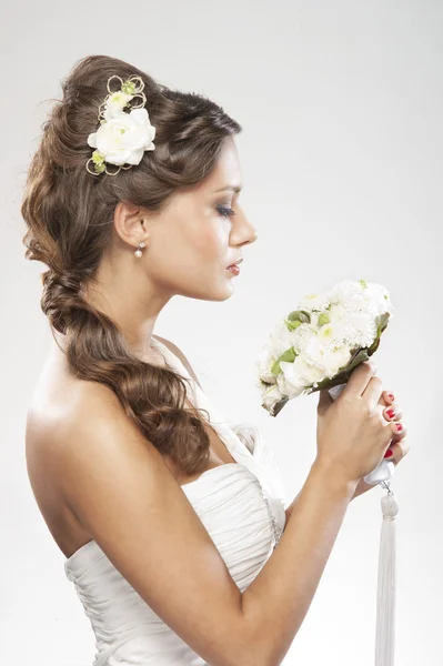 Giovane sposa attraente con il bouquet di rose bianche Foto Stock