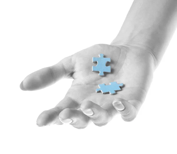 Twee stukjes van de puzzel in hand — Stockfoto