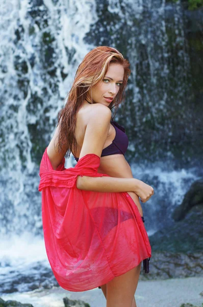 Ung och vacker tjej i bikini som badar i ett vattenfall — Stockfoto