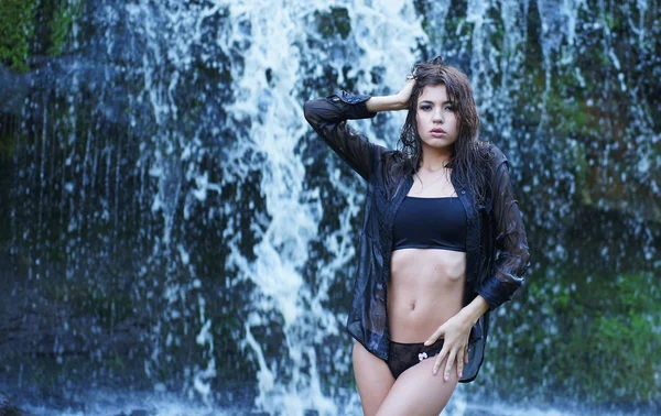 Menina jovem e bonita de biquíni tomando banho em uma cachoeira — Fotografia de Stock