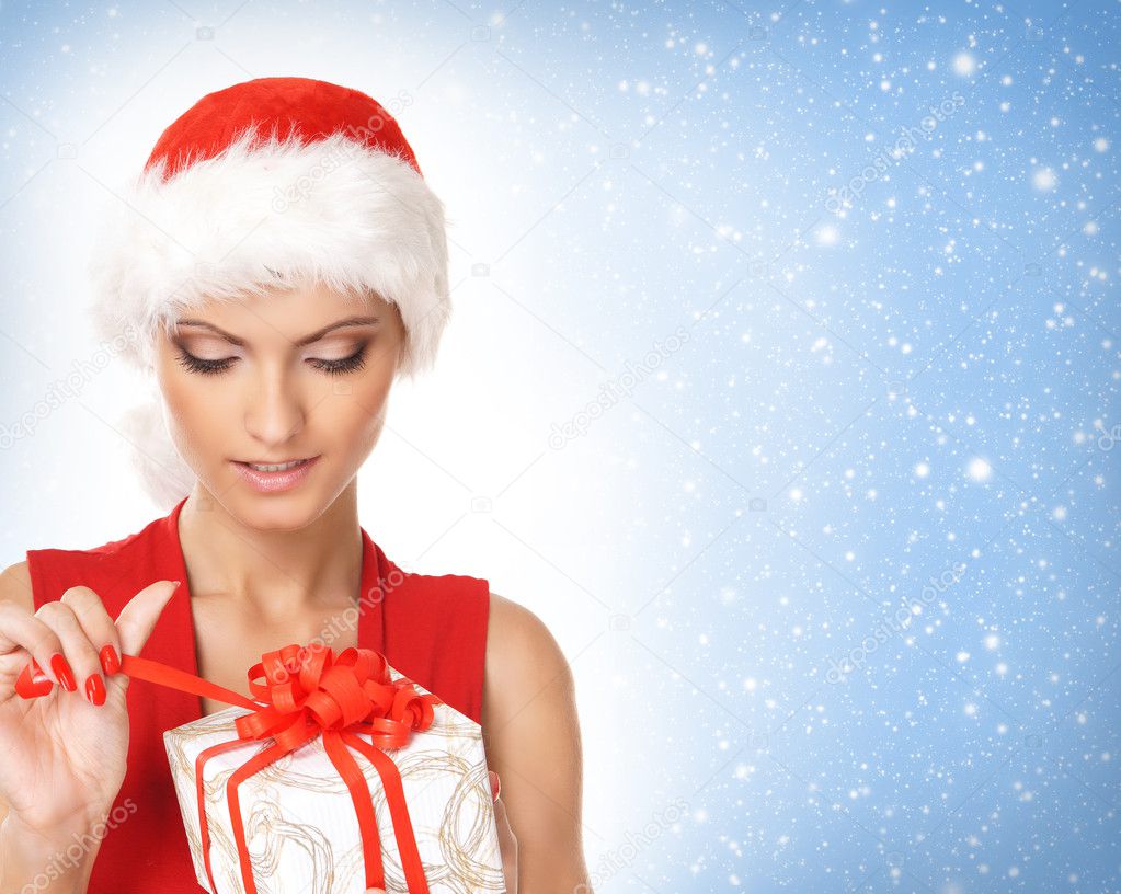 Portrait of young, sexy female Santa isolated on blue
