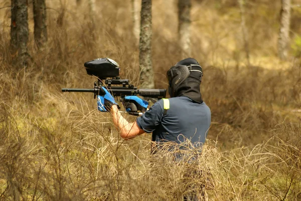 Paintball player with marker on forest game — Stock Photo, Image