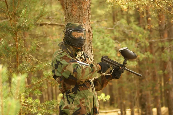 Jogador de Paintball com marcador no jogo da floresta — Fotografia de Stock