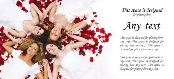 Молодые и здоровые девушки над белым шелком и лепестками роз — стоковое фото