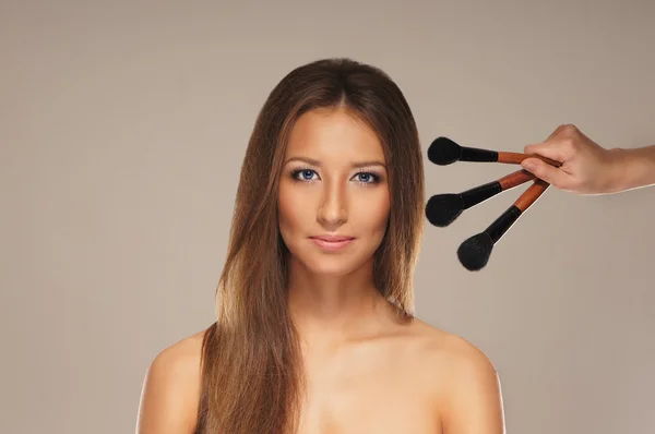 Studio photo of make-up process over grey background — Stock Photo, Image