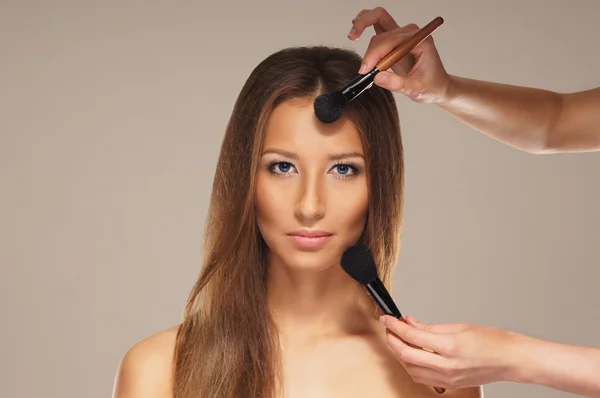 Studio photo of make-up process over grey background — Stock Photo, Image