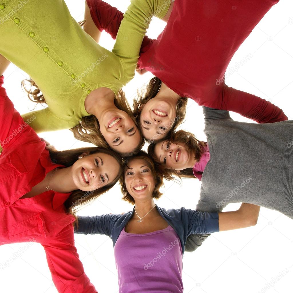 Group of smiling teenagers staying together and looking at camera