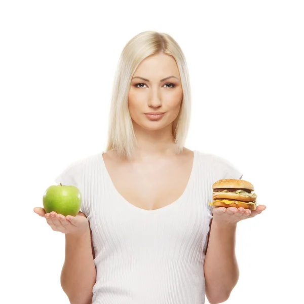 Menina atraente jovem fazendo escolha entre alimentos saudáveis e prejudiciais — Fotografia de Stock