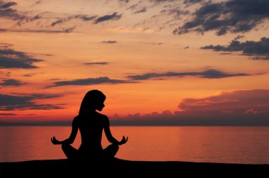 gün batımı arka plan üzerinde yoga egzersiz yaparak genç bir kadın silueti