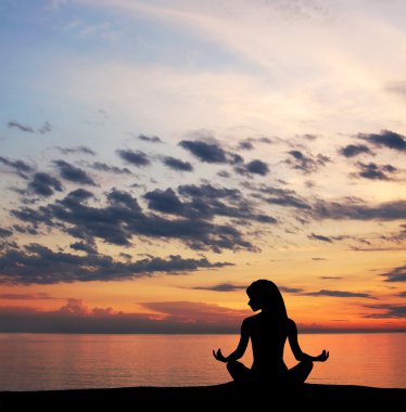gün batımı arka plan üzerinde yoga egzersiz yaparak genç bir kadın silueti