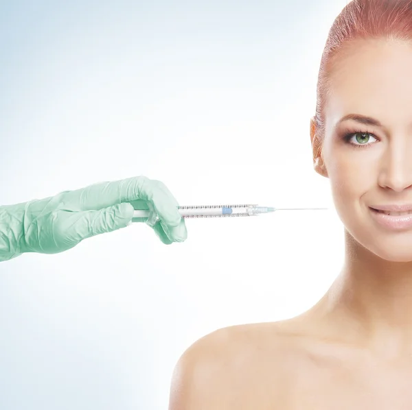 Hermosa mujer recibe una inyección en su cara — Foto de Stock