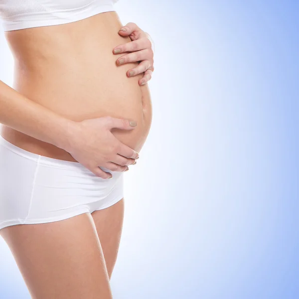 Beautiful belly of young attractive pregnant woman over white ba — Stock Photo, Image